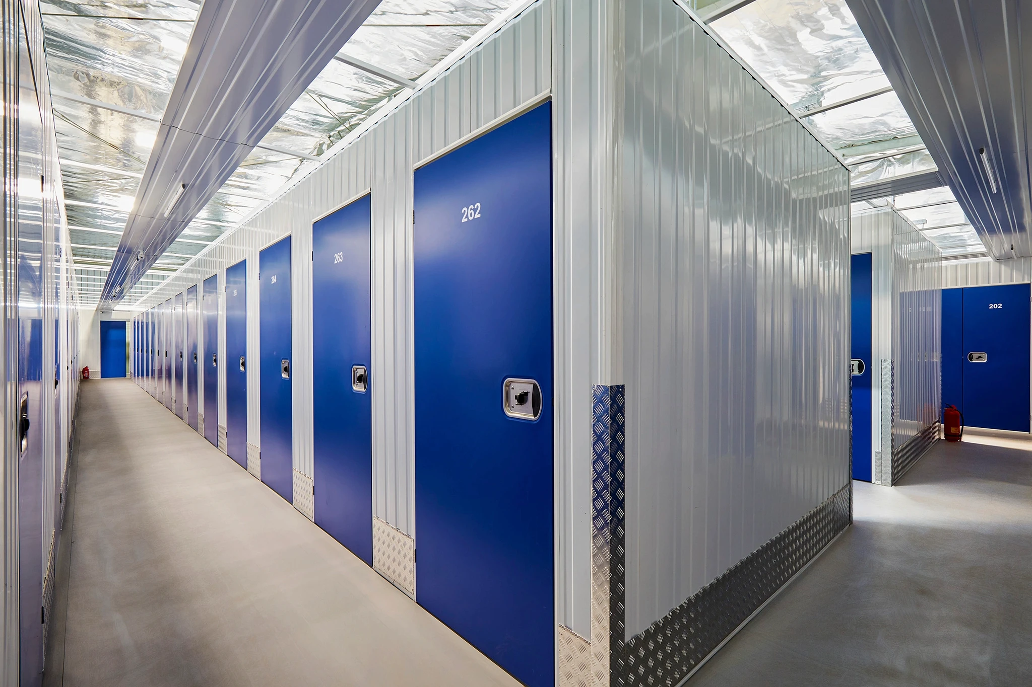 Modern self-storage facility corridor with blue storage units - Boxy Capital value-add investment target